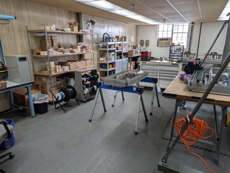 HW Dynamics shop interior with workbenches, wire reels, and panel in progress